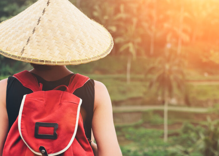 Jeune femme avec un chapeau et sac à dos traditionel de l'Asie