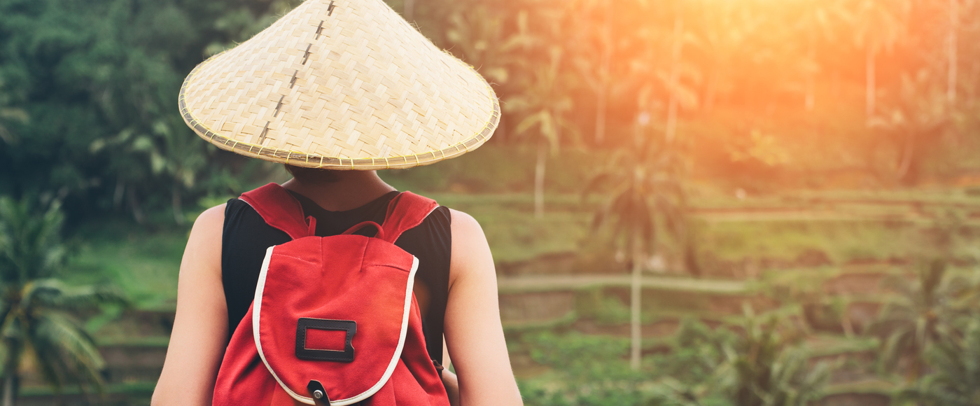Jeune femme avec un chapeau et sac à dos traditionel de l'Asie