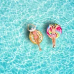Deux personnes flottent sur des bouées gonflables dans une piscine turquoise, pendant la canicule en France